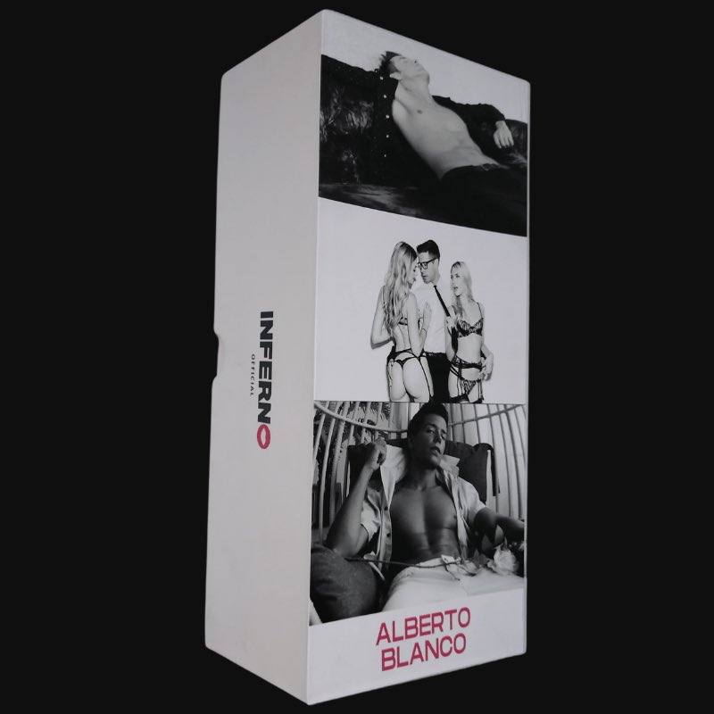 A brown, realistic dildo with a detailed, lifelike texture. It is shown next to a photo album with erotic images in the background.